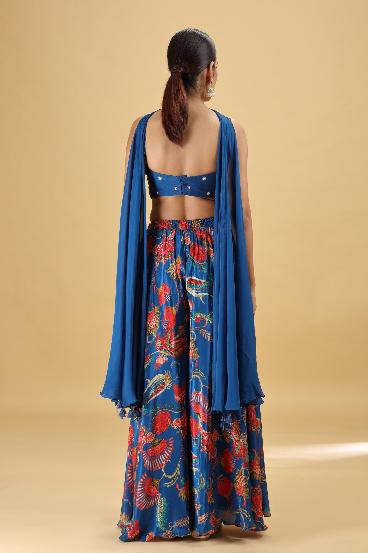 Woman wearing a blue floral outfit with a beige background