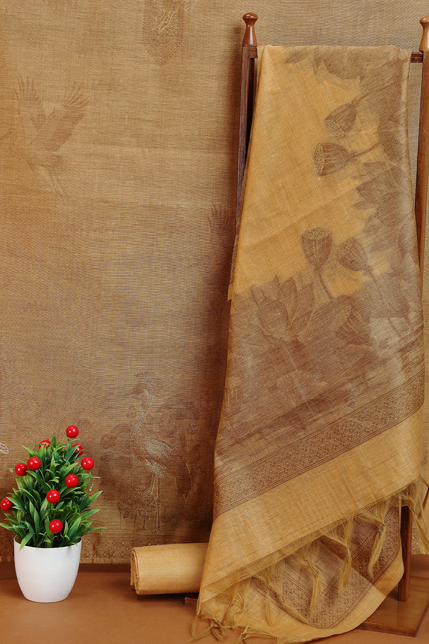 gold silk fabric draped over a wooden rod with a plant in the foreground against a textured wall.