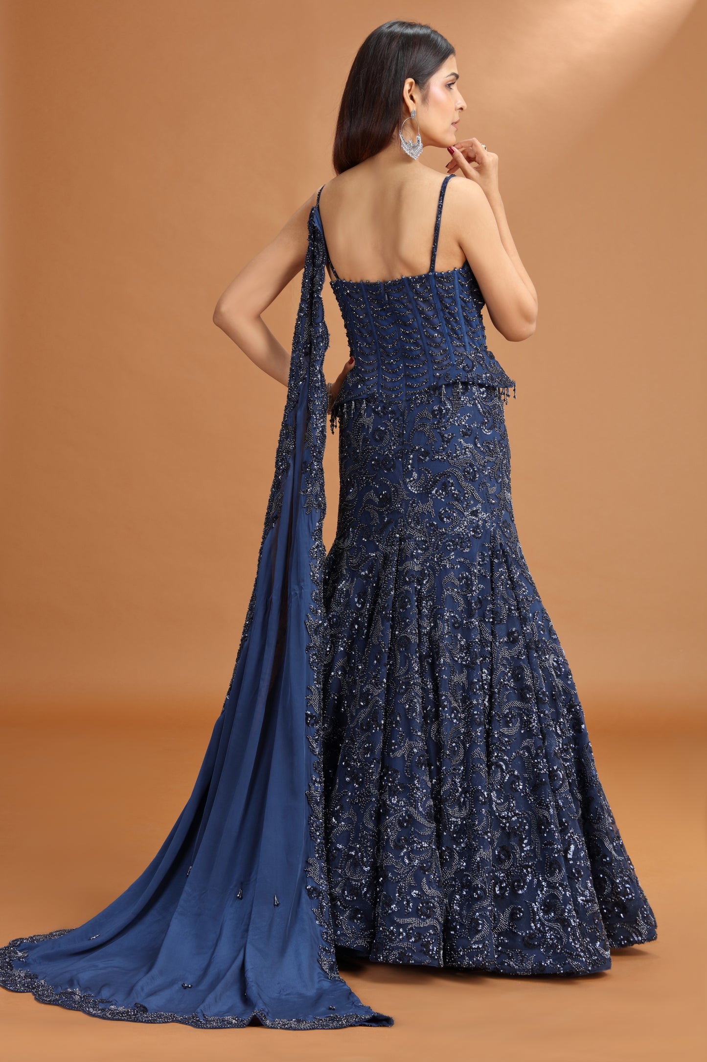 Woman wearing a blue party gown with on a brown background