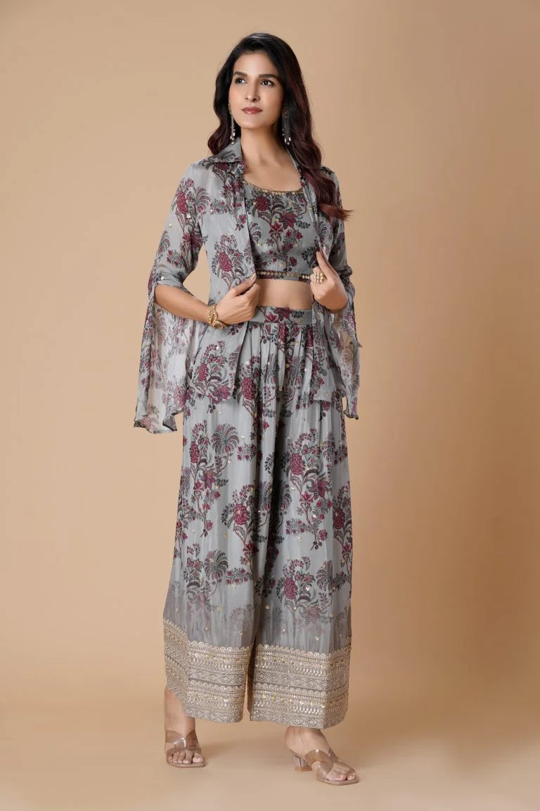 Woman in a gray floral two-piece outfit with a flowy jacket and palazzo pants