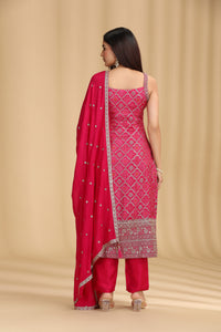 Woman wearing a pink traditional outfit with a matching dupatta on a beige background