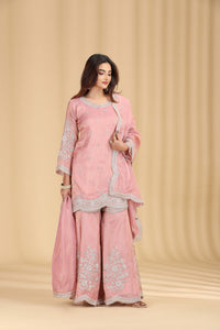 Woman wearing a pink traditional outfit with floral patterns on a beige background