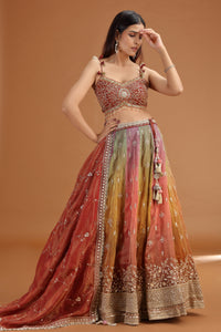 Woman wearing a maroon multicolored lehenga with mirror zardosi work