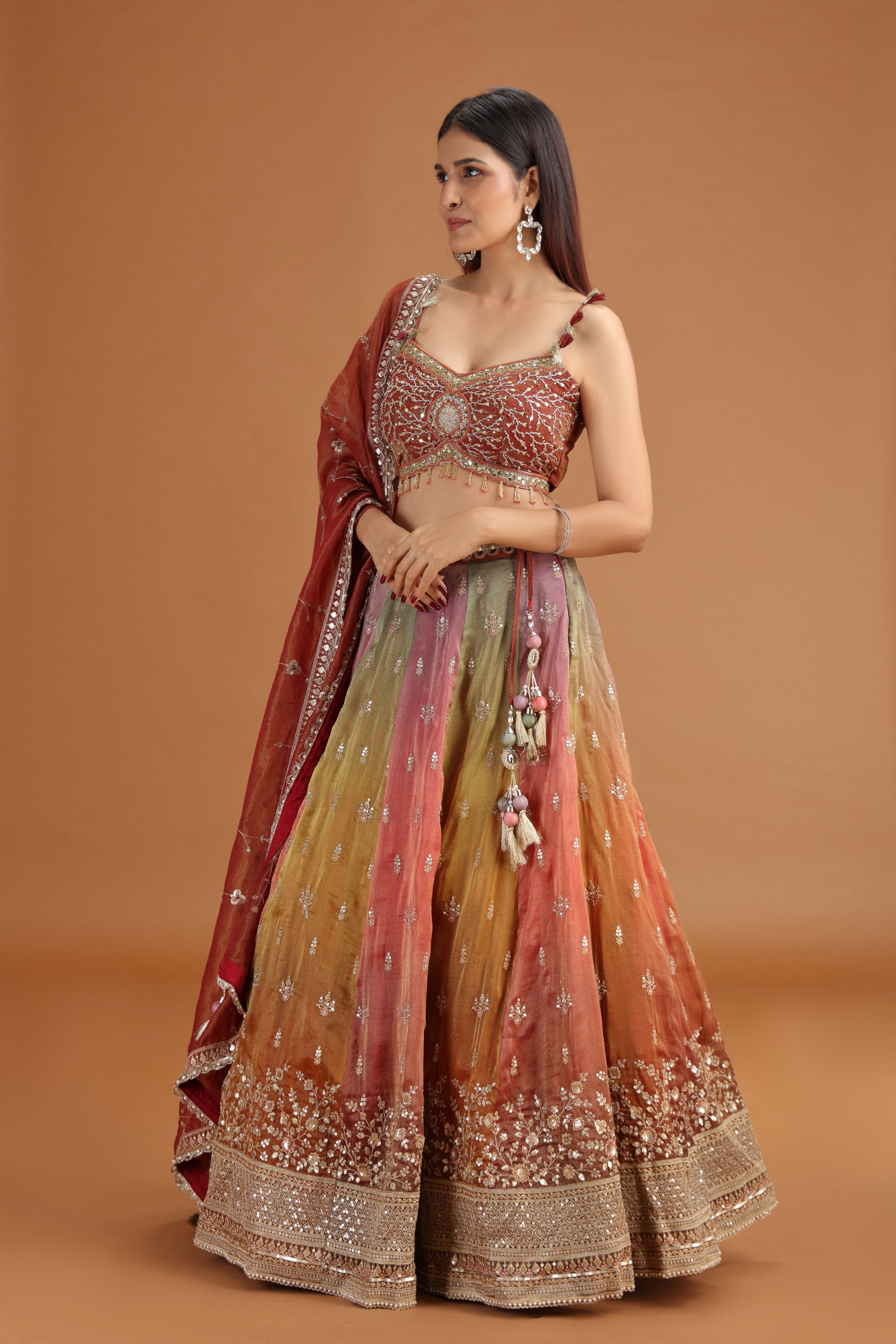 Woman wearing a maroon tissue lehenga with a red dupatta