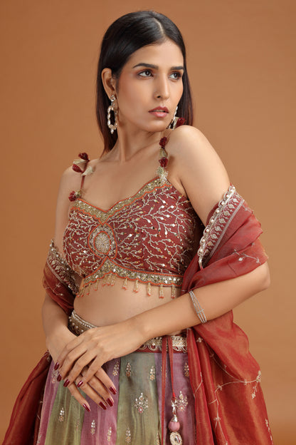Woman wearing a traditional embroidered maroon tissue lehenga