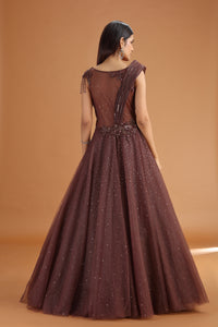 Woman wearing a brown evening gown with a textured bodice against a matching background