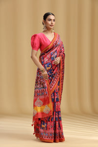 Woman wearing a colorful saree with a pink blouse against a beige background
