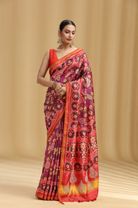 Woman wearing a colorful saree with a patterned design on a beige background