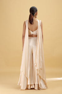 Woman wearing a beige outfit with a drape on a beige background