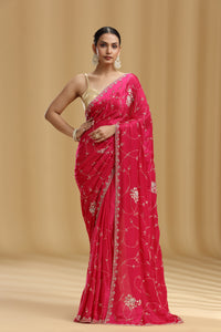 Woman wearing a pink saree with a beige background