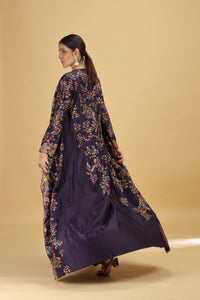 Woman wearing a dark blue floral dress against a beige background