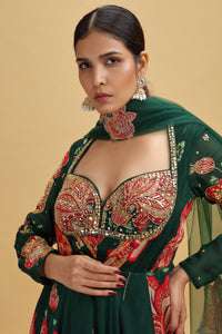 Woman wearing a traditional embroidered outfit with a green dupatta against a beige background