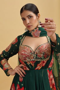 Woman wearing a traditional green and red embroidered crepe gown with a beige background