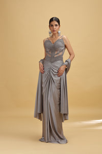 Woman wearing a grey lycra saree against a beige background