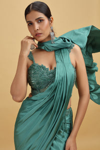 Woman in a crepe green saree with a net blouse 