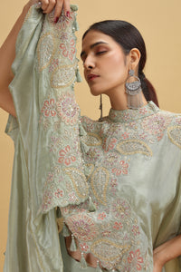Woman wearing a pista green embroidered salwar suit