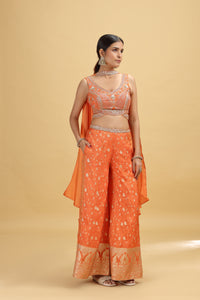 Woman wearing an orange traditional outfit with a beige background