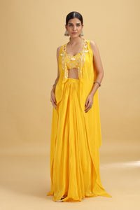 Woman wearing a yellow salwar suit with floral blouse on a beige background