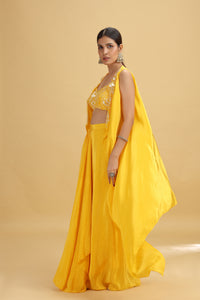 Woman wearing a yellow crepe suit with a matching blouse against a beige background