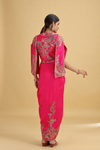 Woman wearing a pink salwar kameez with intricate embroidery on a beige background