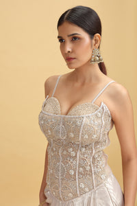 Woman wearing a silver sequin dress against a beige background