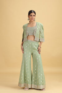 Woman wearing a Green Banarasi Silk Suit on a beige background