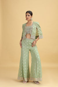 Woman wearing a light green traditional outfit with a beige background