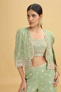Woman wearing a green banarasi silk Suit with a matching jacket on a beige background