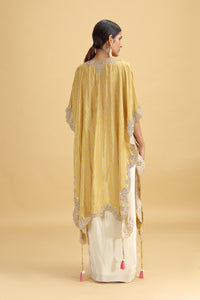Woman wearing a mustard yellow embroidered dupatta on a beige background