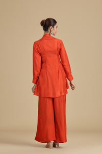Woman backview wearing an orange outfit on a beige background