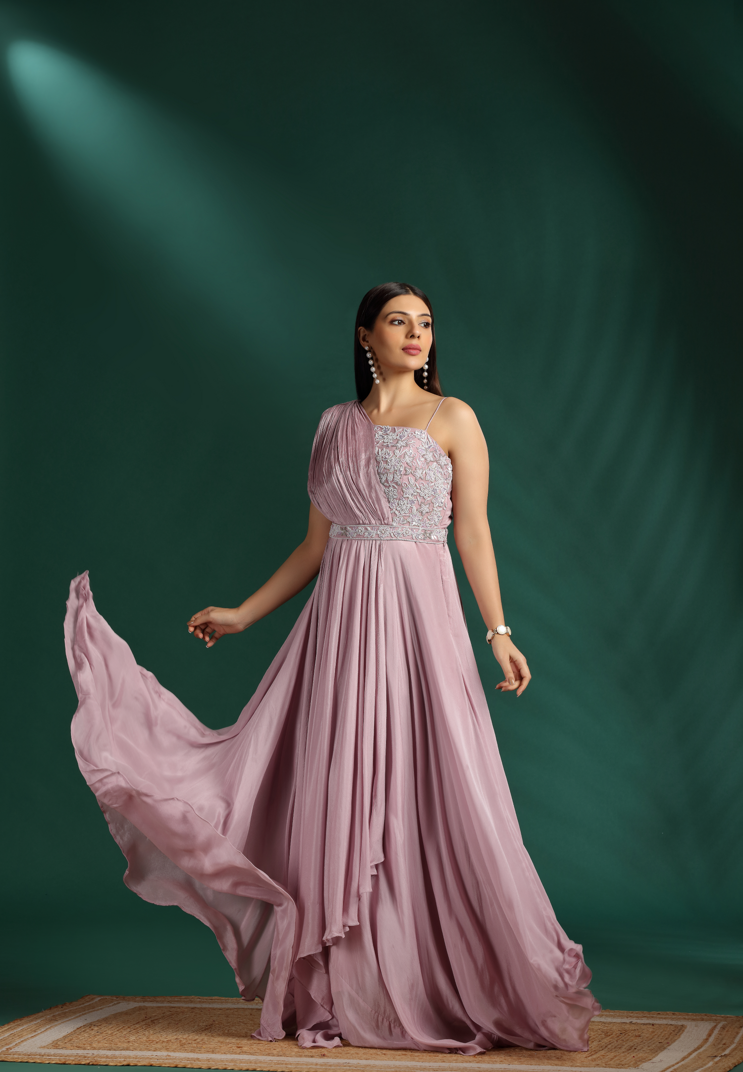 Woman in a pink Salwar Kameez against a green background