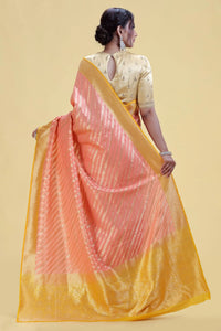 Woman wearing a Rose Pink Kathan Silk Saree with a pink blouse against a beige background