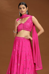 Woman wearing a bright pink silk lehenga set 