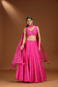 Woman wearing a bright pink silk lehenga set 