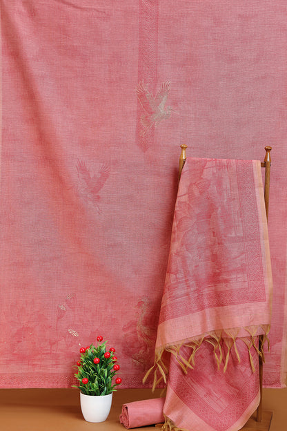 Maroon fabric with a plant and rolled-up fabric on a wooden surface