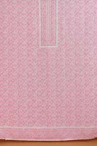 Pink fabric with a geometric pattern on a wooden surface