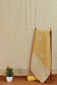 Golden towel with white patterns hanging on a wooden rack against a patterned wall.