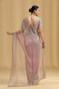 Woman wearing a sparkling saree with a gold background