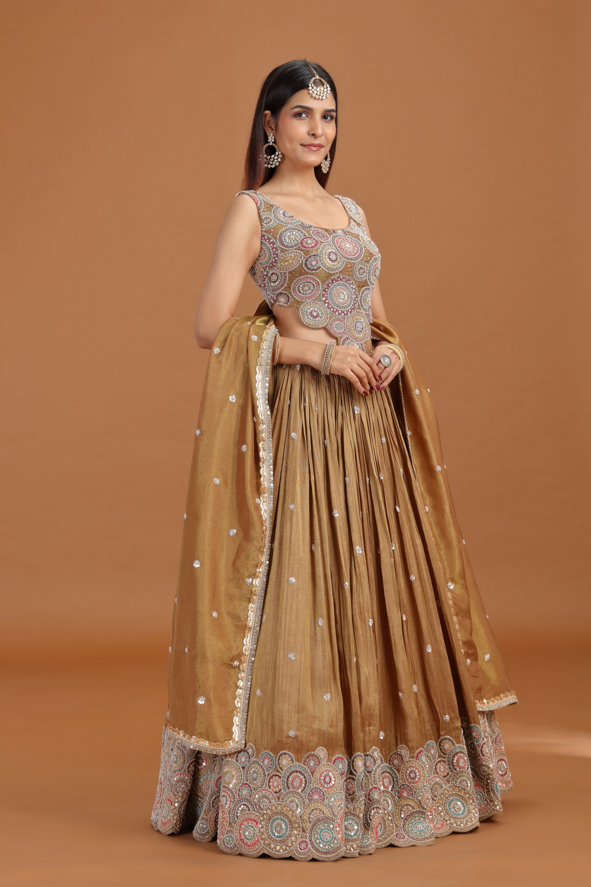 Woman wearing a dusty gold sequin work lehenga set from Roopkala