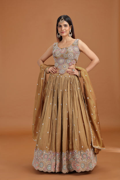Woman posing in a dusty gold tissue lehenga with aari pearl work 