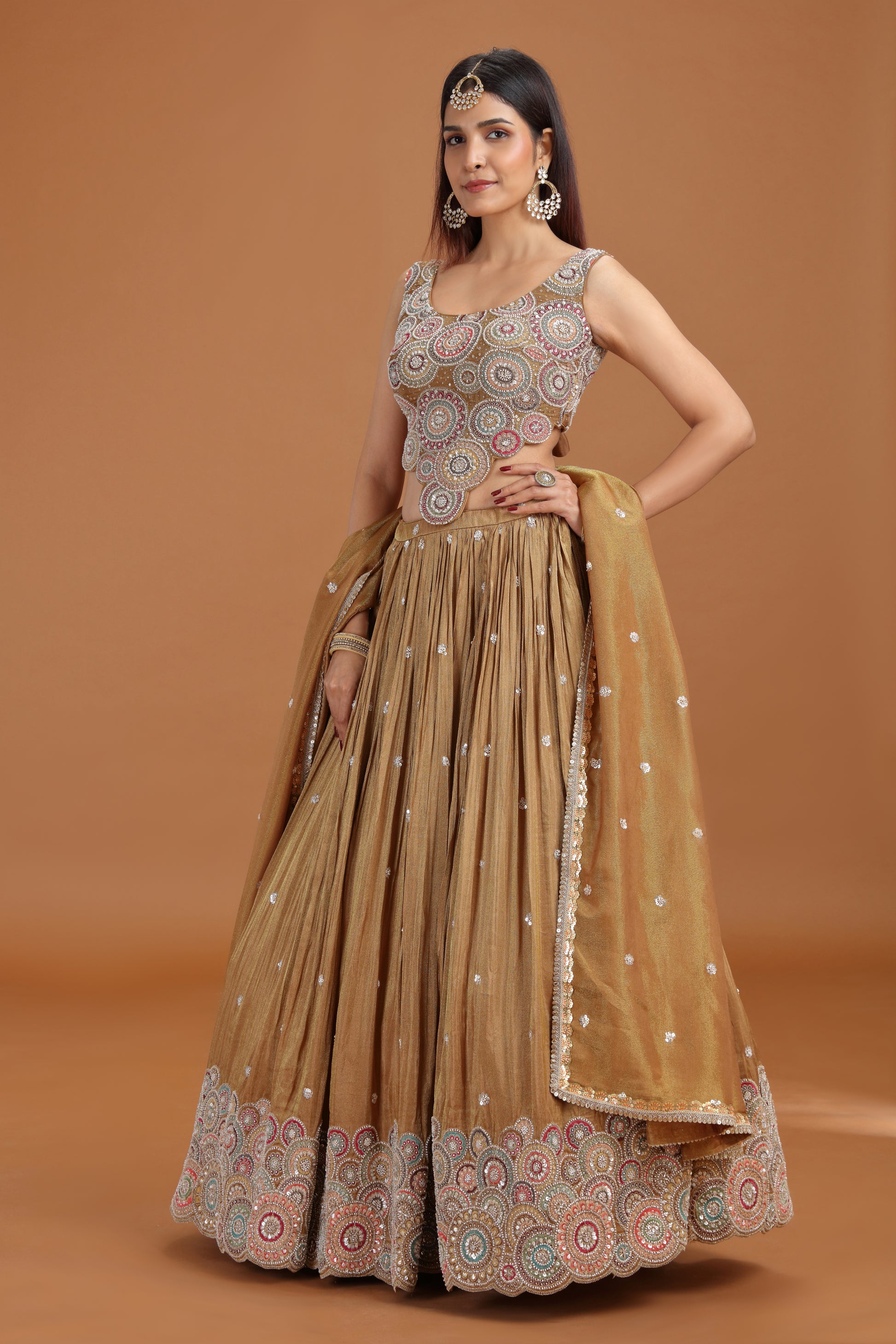 Woman wearing a Roopkala dusty gold tissue lehenga with aari pearl work