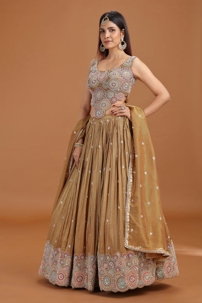 Woman wearing a Roopkala dusty gold tissue lehenga with aari pearl work