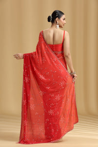 Woman wearing a red ombre saree with a beige background