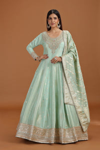 Woman wearing a Pista Green Banarasi Silk Gown with mirror work
