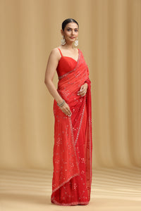 Woman wearing a red saree with a beige background