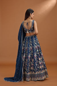 Woman wearing a blue art floral lehenga with Crepe Dupatta & Zari Work