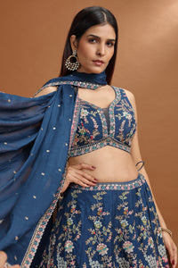 Woman wearing a blue embroidered Blue Art Raw Silk Lehenga Set