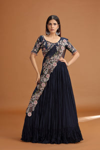 Woman wearing a black floral dress against a brown background