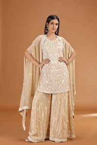 Woman wearing a beige crepe suit outfit with a plain background