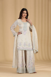 Woman wearing a traditional outfit with floral patterns on a beige background